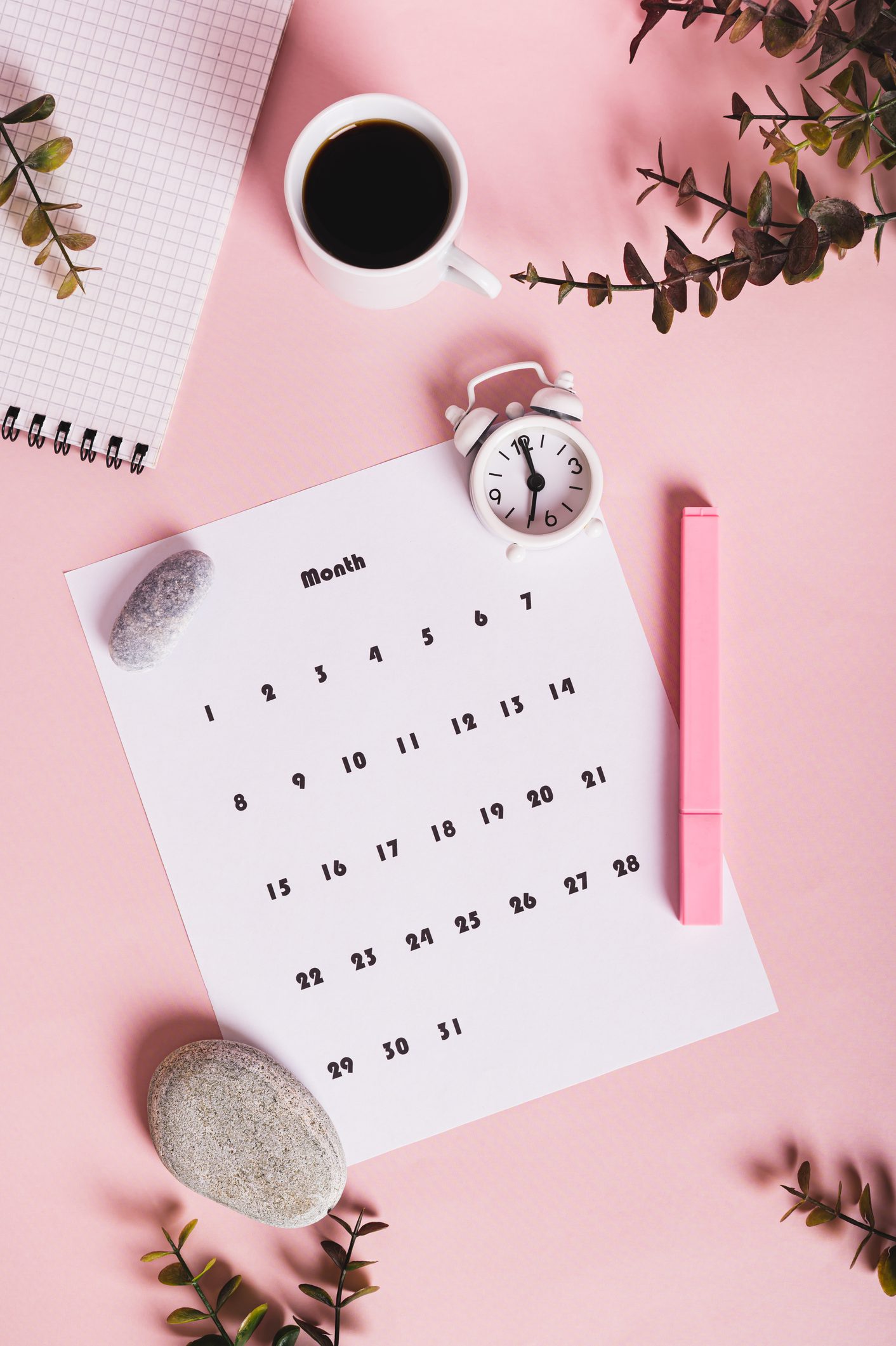 Calendar, alarm clock, notebook and pen on a pink background top and vertical view