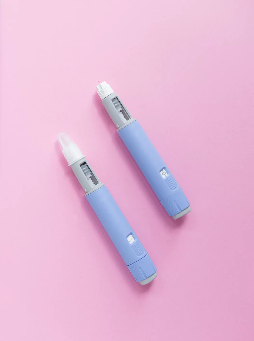 Delicious sweet pink donut on a blue background and two Ozempic pen injections on a pink background. Sugar and medicana, concept. Weight loss. subcutaneous injection of antidiabetic medication mounjaro weight loss injection